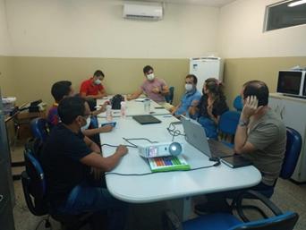 Grupo de pessoas sentadas ao redor de uma mesa

Descrição gerada automaticamente